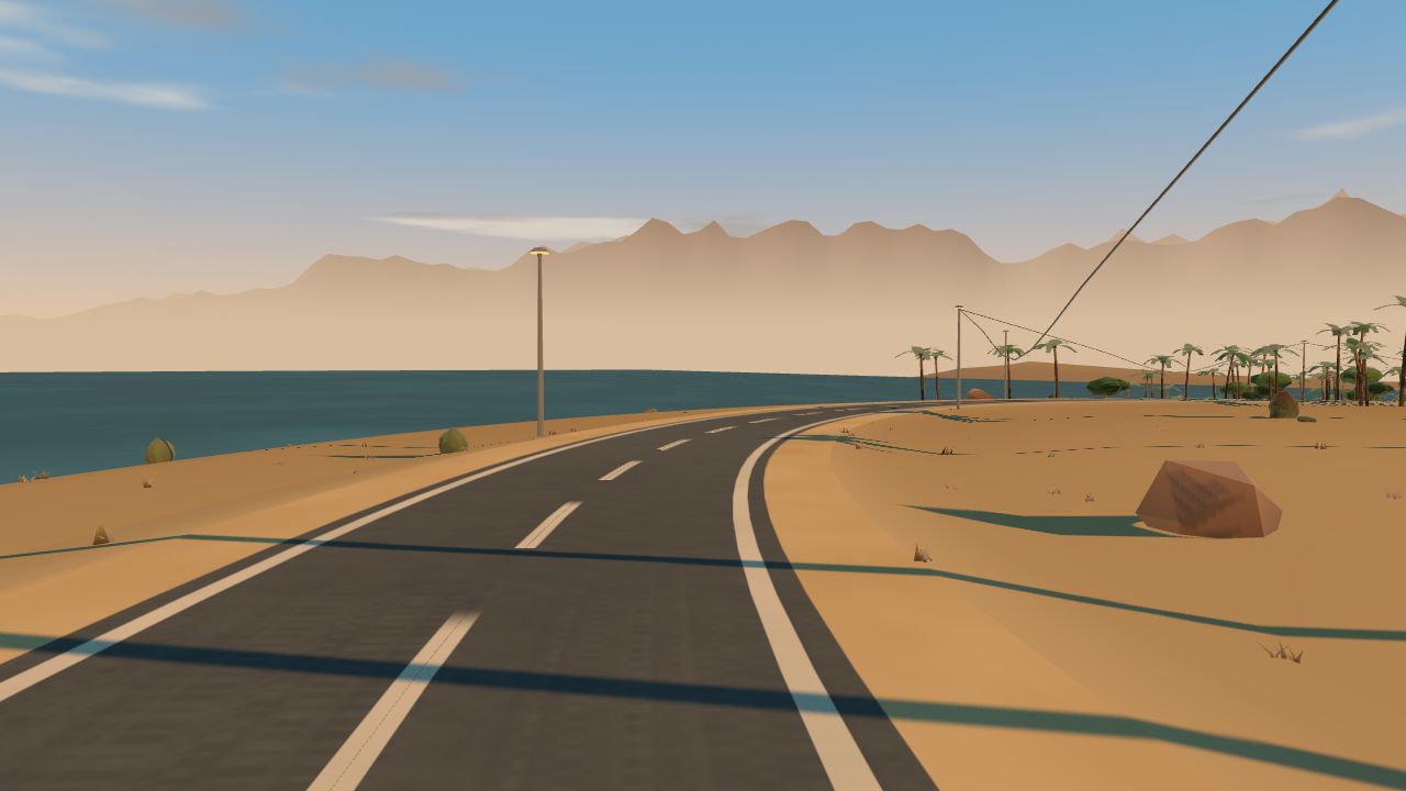 The road bending along the shore of a desert lake, mountains behind